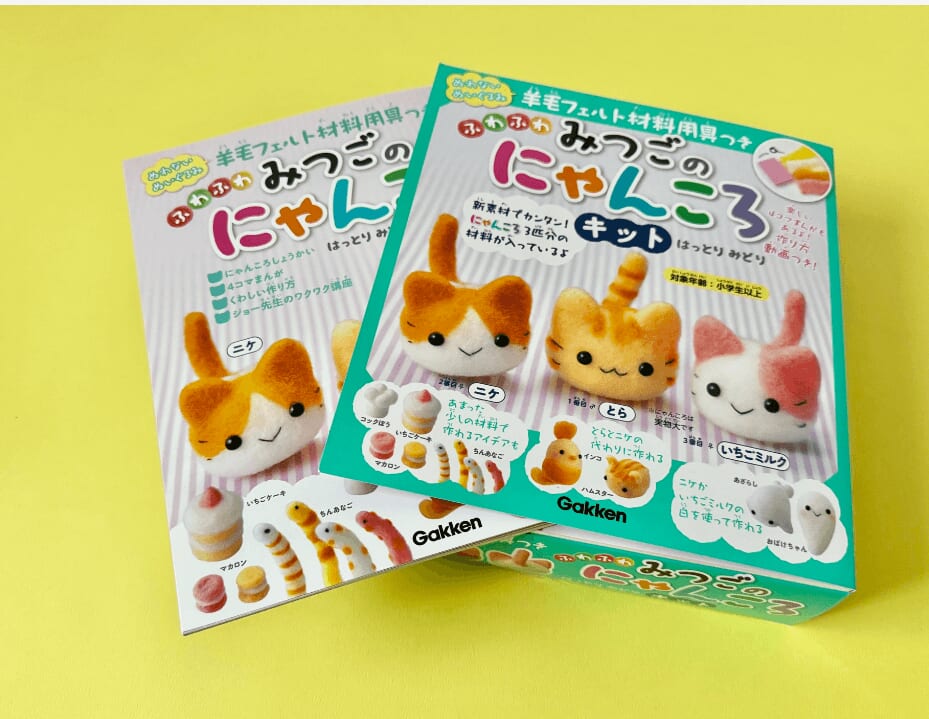 『羊毛フェルト材料用具つき　ふわふわ みつごのにゃんころキット』キット。箱の上部にパラパラめくれるように、本が入っていて、とりはずせます。画像